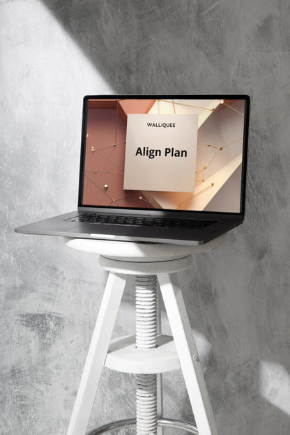 Laptop on a stool with a screen displaying 'Align Plan' against a gray wall.