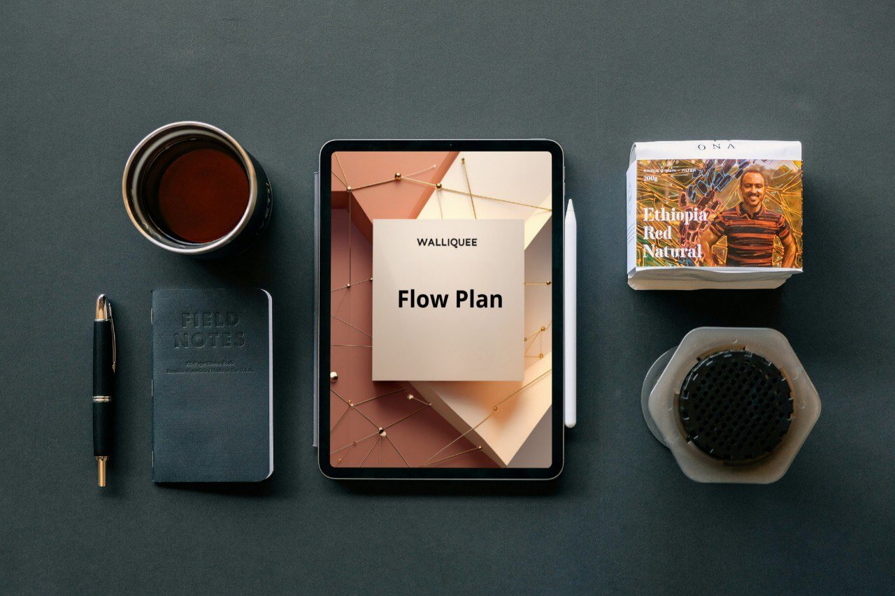 Tablet displaying a 'Flow Plan' SMM guide, coffee cup, notebook, pen, and coffee filter on a dark surface.