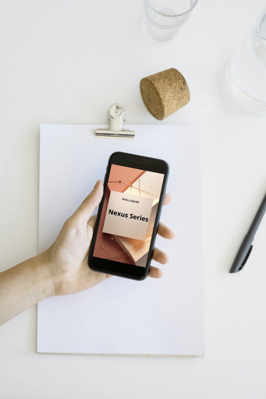 Hand holding a smartphone with a 'Nexus Series' SMM guide display on a white surface with a pen and cork.