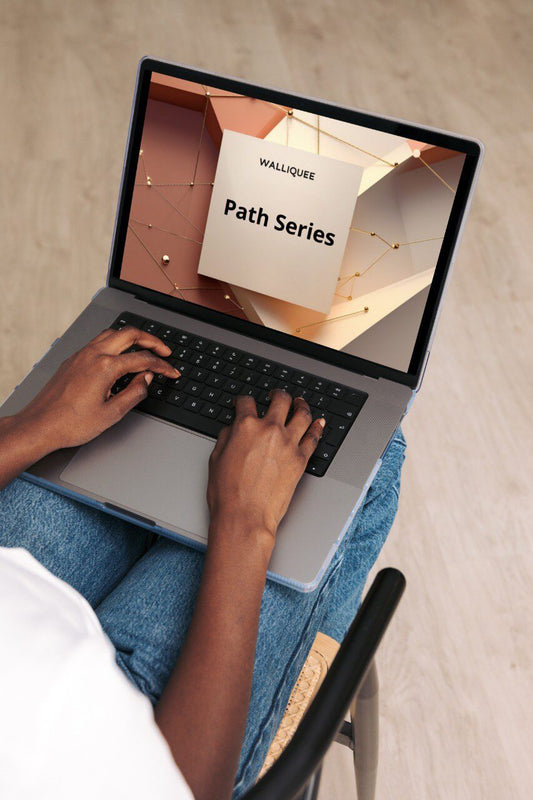 Person using a laptop with a screen displaying SMM guide 'WALLIQUE Path Series' on a textured surface.